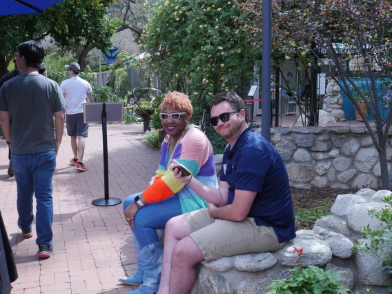 Academic Advisors seated on a stone wall at event check in.