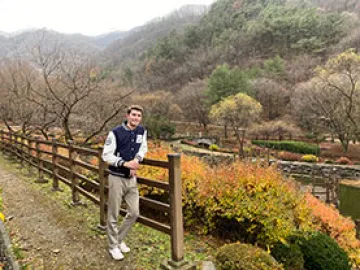 Man standing by a fence during Autumn in Seoul